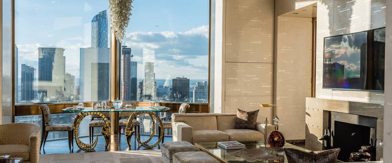 A corner suite laid for two, floor-to-ceiling windows over the city