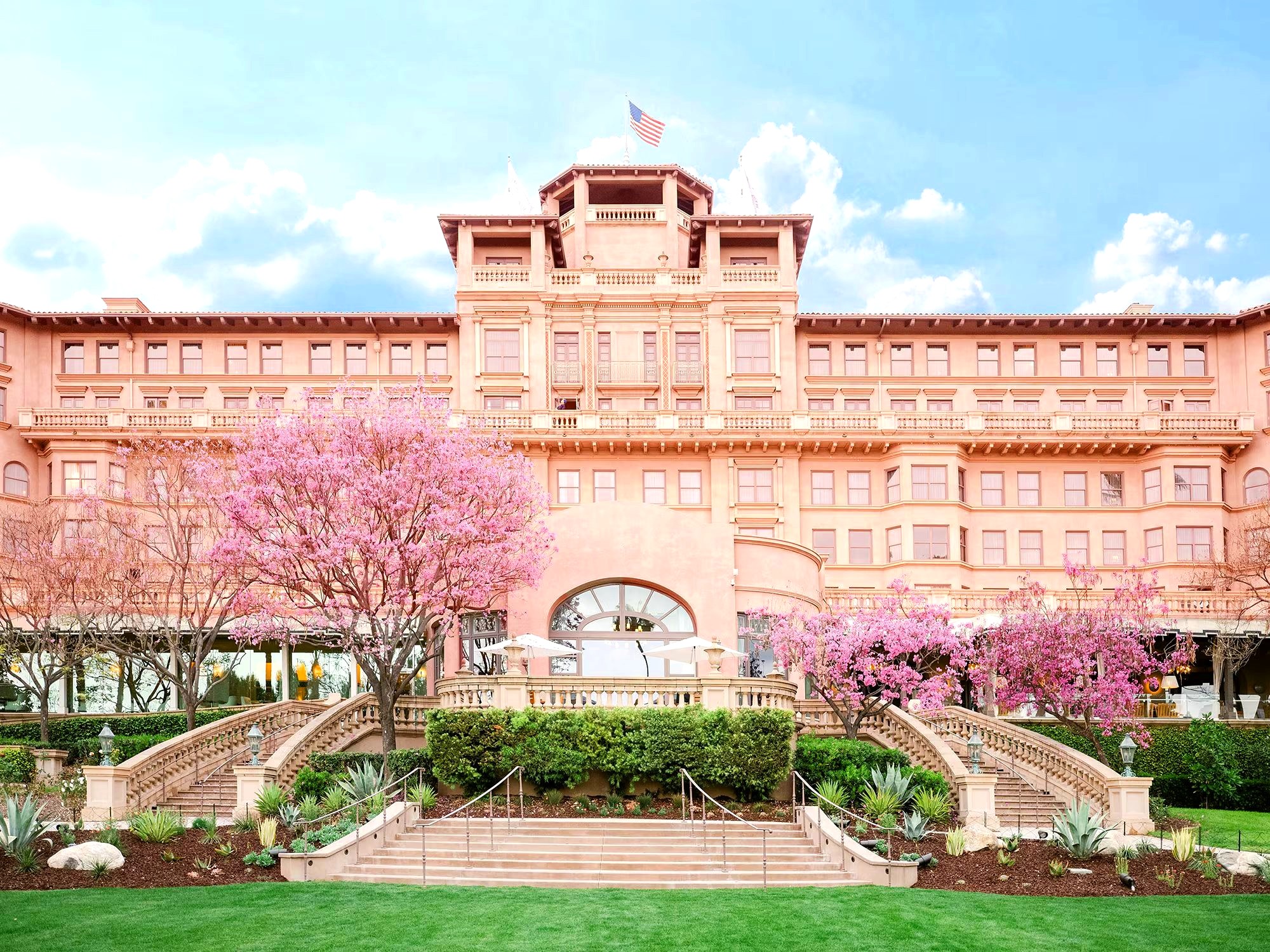 The Langham's pink façade with blossoming cherry trees