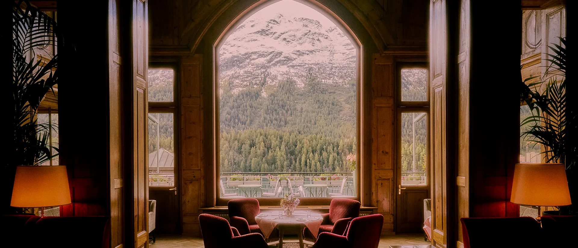 An arched window at Badrutt's Palace, St Moritz, a Leading Hotels member since 1996, looking out to the mountains