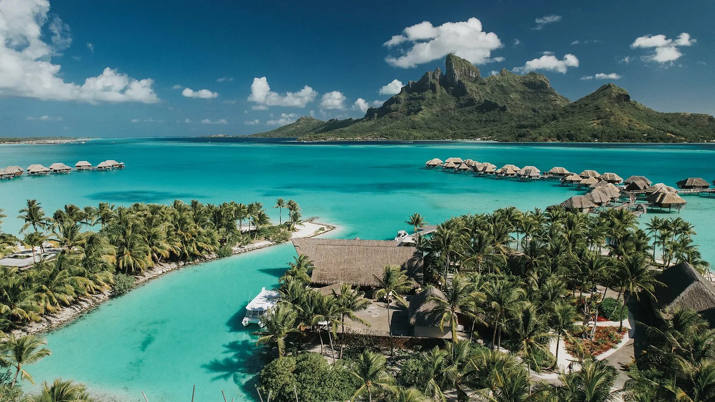 Overwater bungalows on the lagoon at Four Seasons Resort Bora Bora with Mount Otemanu beyond