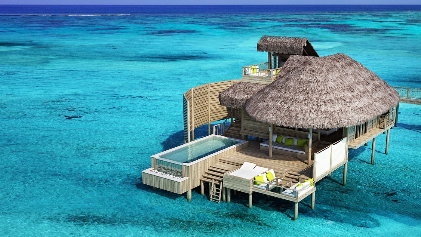 A thatched overwater villa on stilts at Six Senses Laamu, its plunge pool open to the lagoon