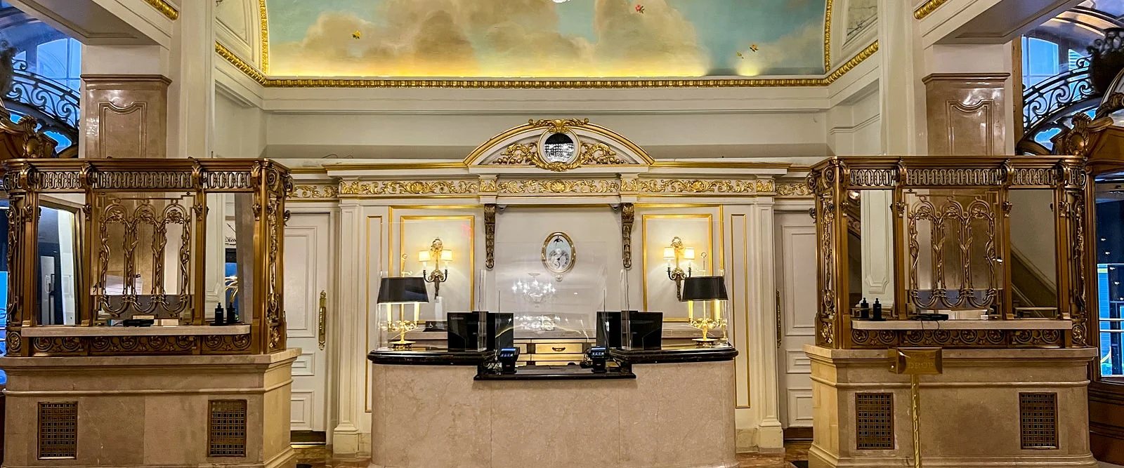 A gilded reception hall with a painted ceiling at a St. Regis hotel