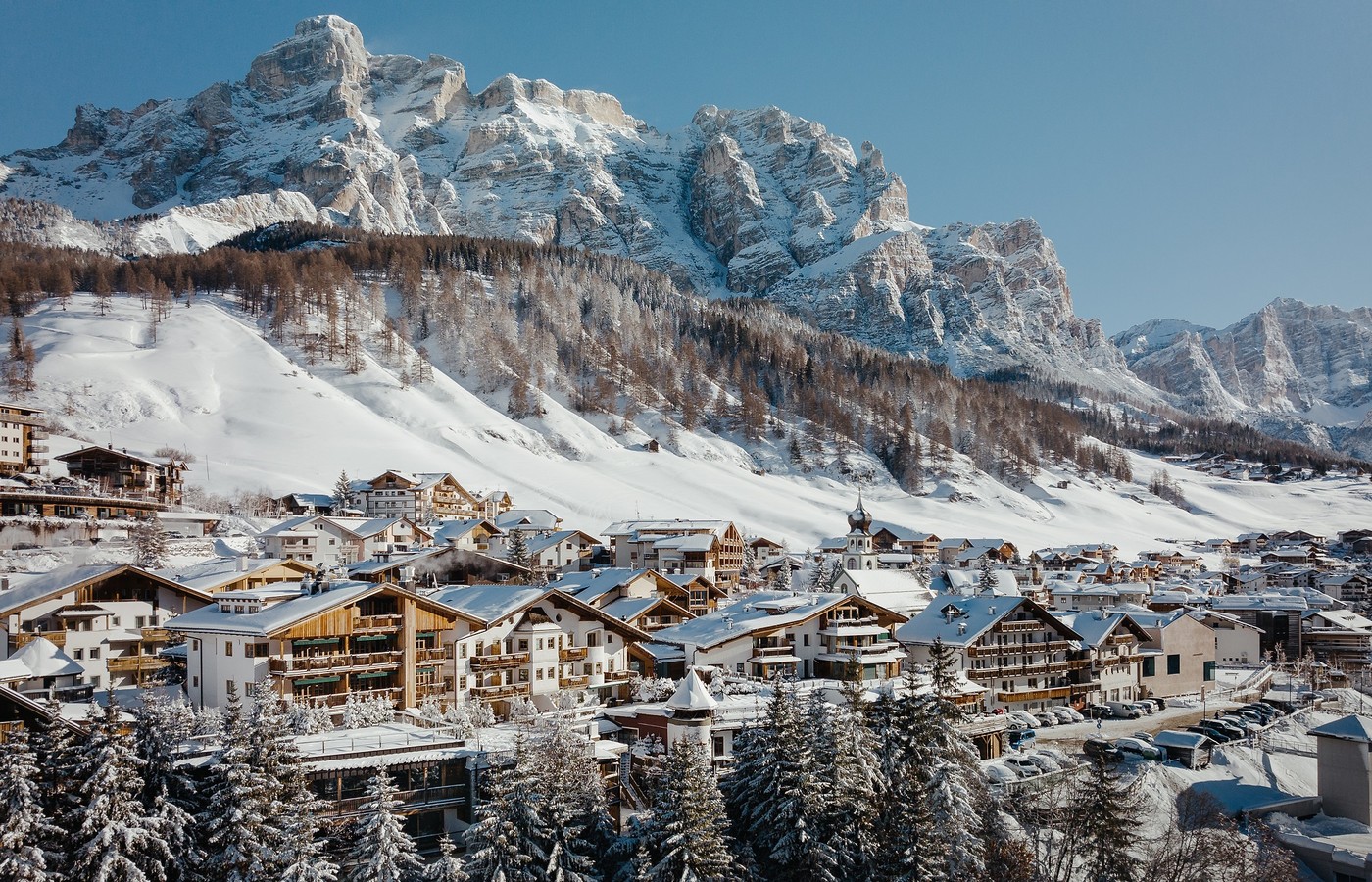 The village of San Cassiano under fresh snow, the Dolomite walls of Alta Badia behind it