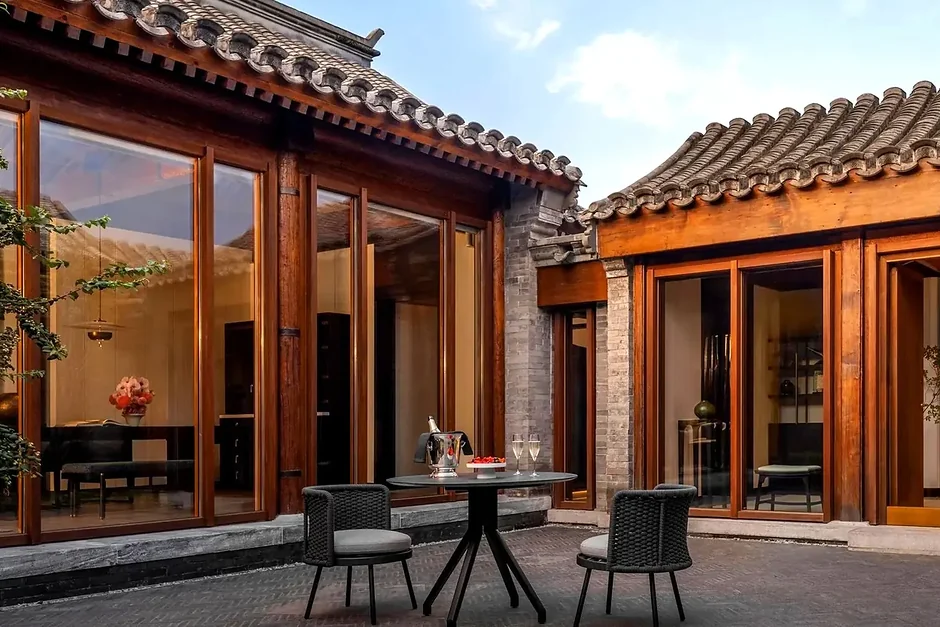 A private courtyard set for two, timber doors opening onto the terrace