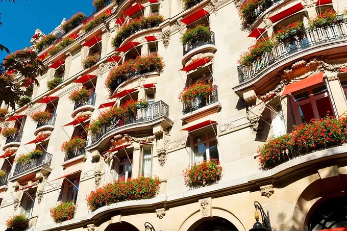 The red awnings and geraniums on the facade of Hotel Plaza Athenee, Paris