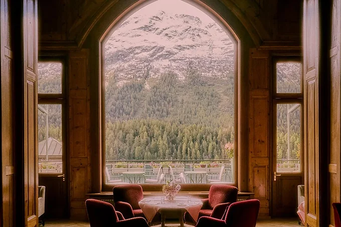 The arched window at Badrutt's Palace, St Moritz, looking out to the mountains