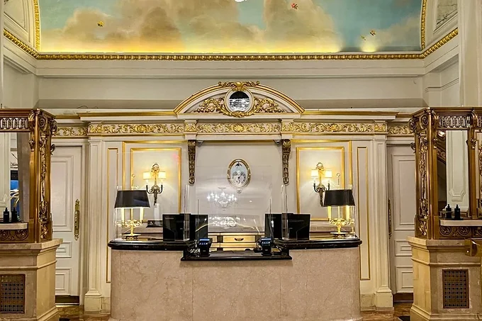 A gilded reception hall with a painted ceiling at a St. Regis hotel