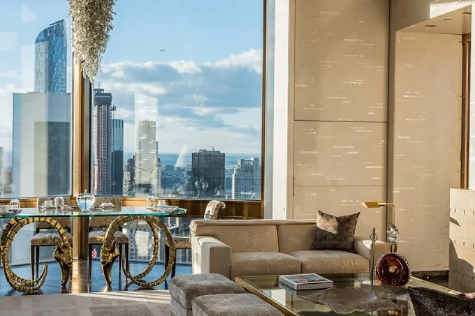 A corner suite laid for two, floor-to-ceiling windows over the city
