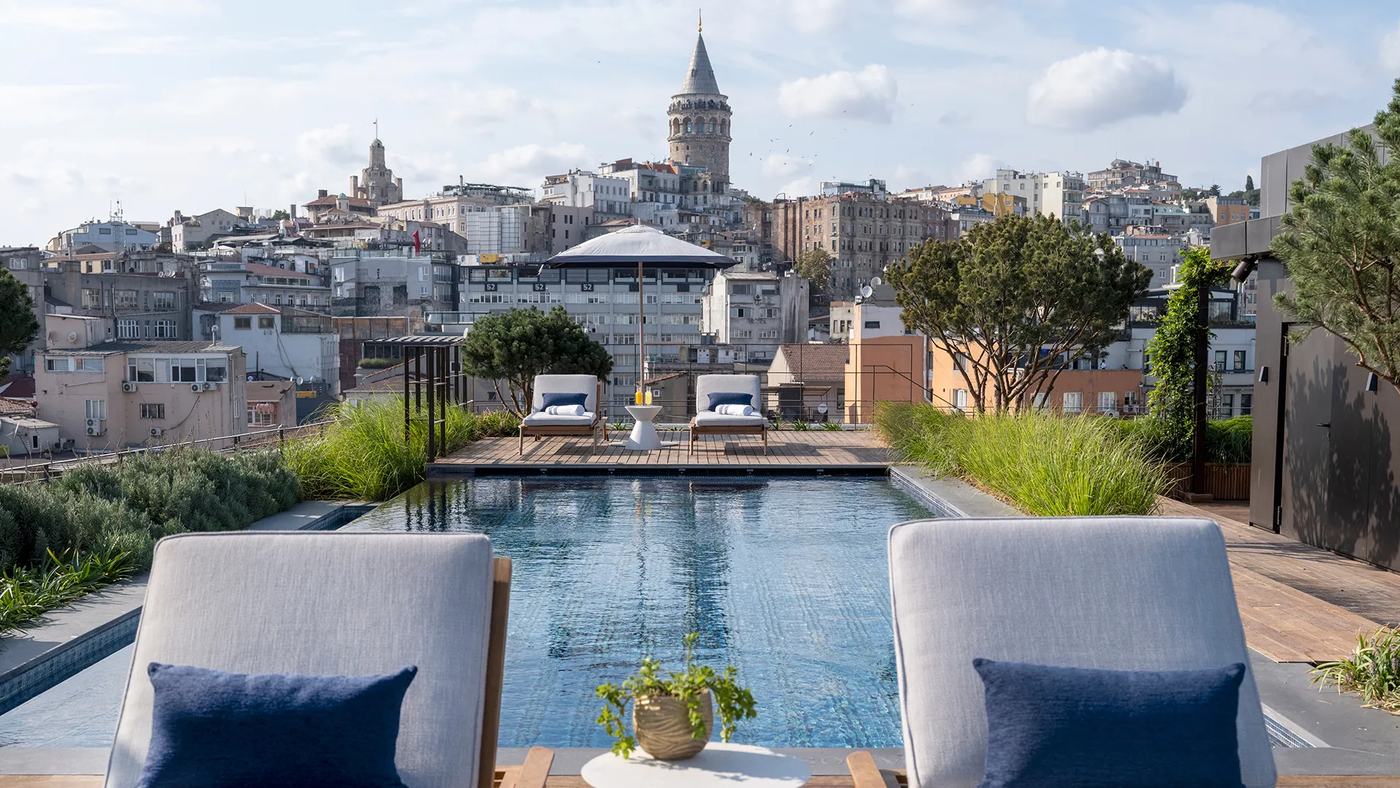 A rooftop pool in Istanbul looking across the rooftops of Karaköy to the Galata Tower