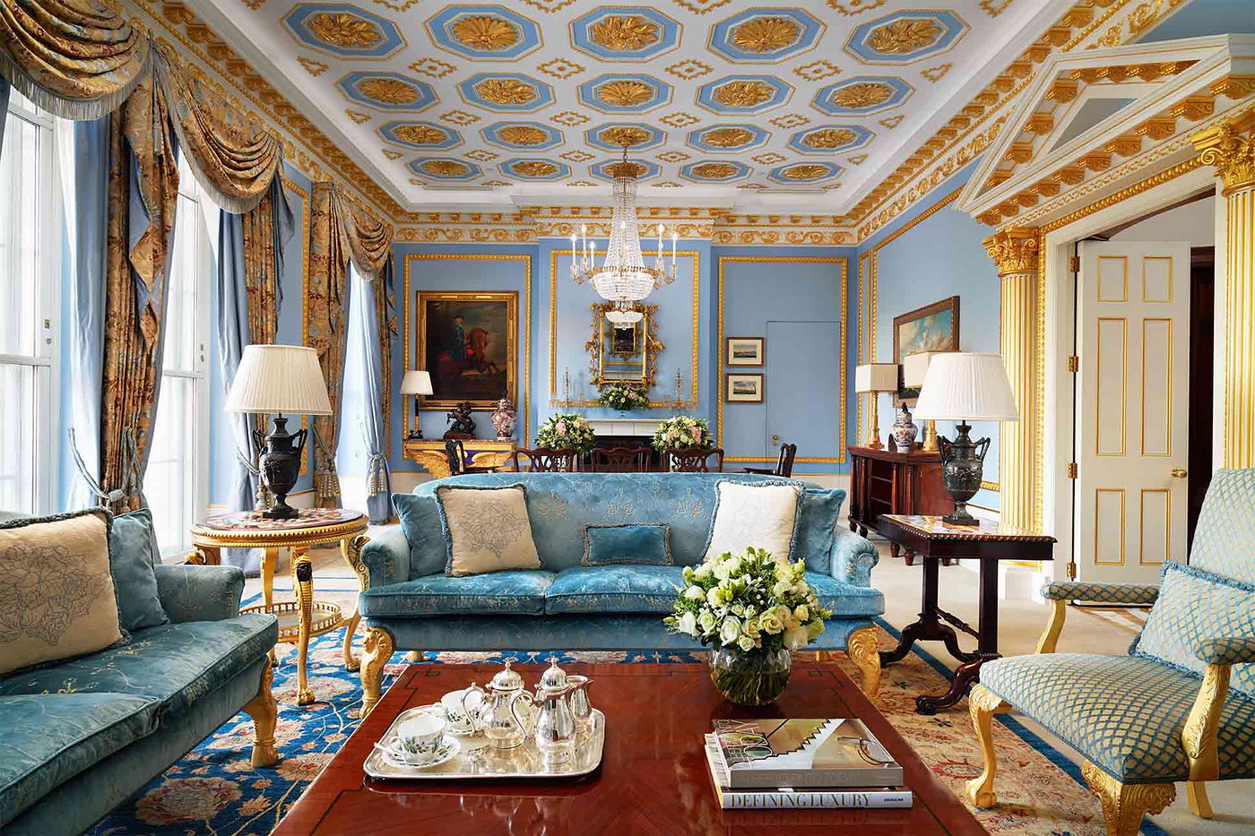 The Withdrawing Room at The Lanesborough laid for afternoon tea, garlands and a decorated tree behind